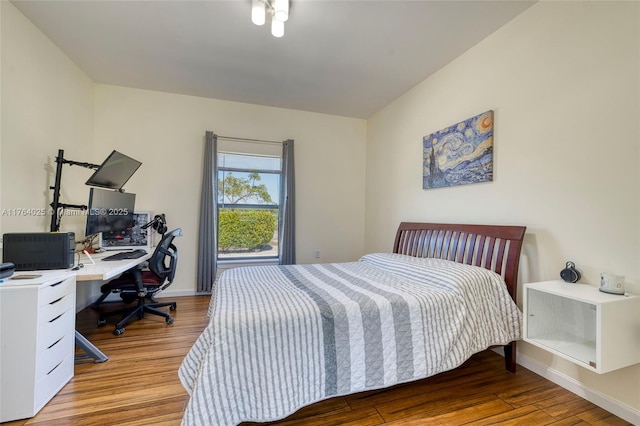 bedroom with baseboards and wood finished floors