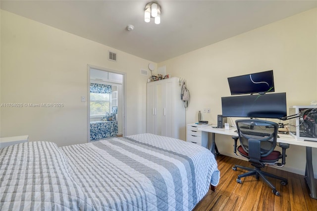 bedroom featuring visible vents and wood finished floors