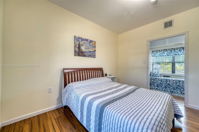 bedroom featuring visible vents, baseboards, and wood finished floors