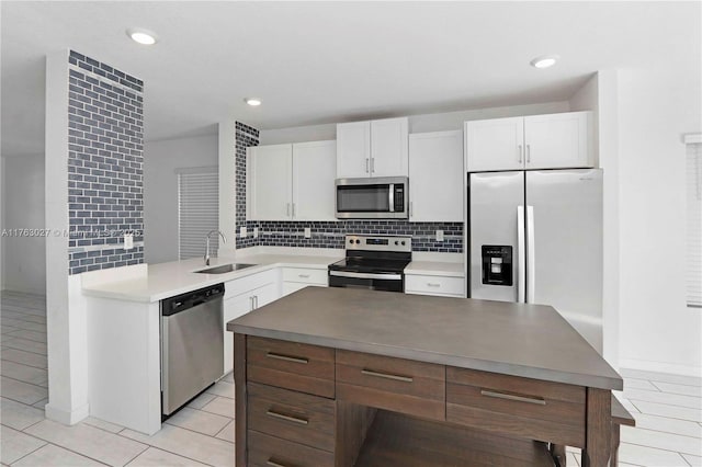 kitchen featuring white cabinetry, tasteful backsplash, appliances with stainless steel finishes, and a sink