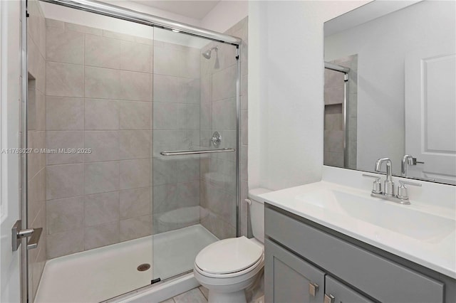 bathroom with vanity, toilet, and a shower stall