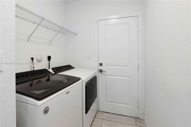 laundry room with laundry area, light tile patterned floors, and washer and clothes dryer