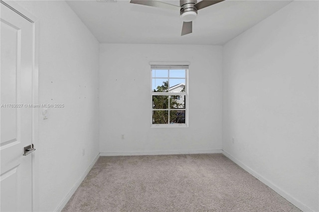 carpeted empty room featuring baseboards and ceiling fan