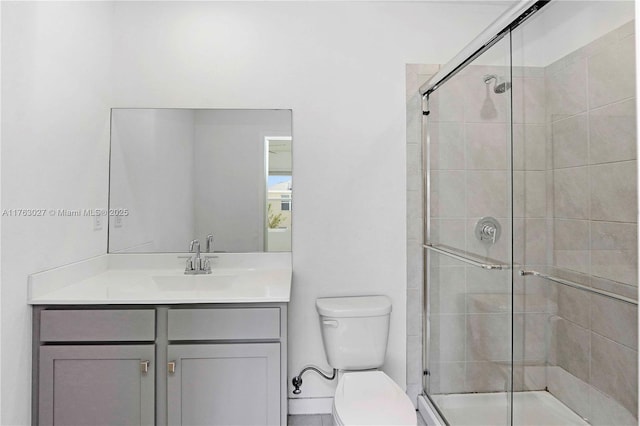 full bath with vanity, a shower stall, and toilet