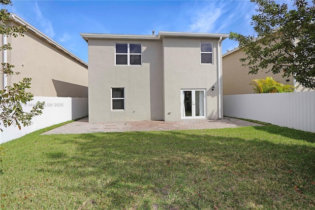 rear view of house with a patio area, stucco siding, and a lawn