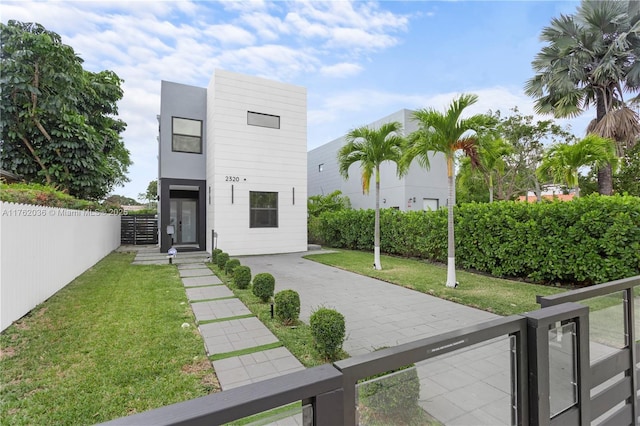 view of front of house with a front lawn and fence