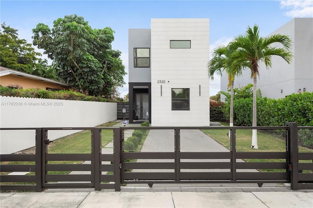 contemporary home with a front lawn, a gate, and a fenced front yard