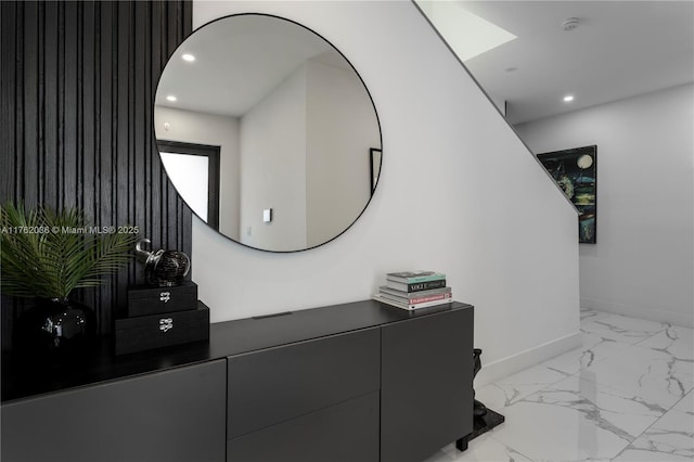 interior space featuring a skylight, recessed lighting, marble finish floor, and baseboards