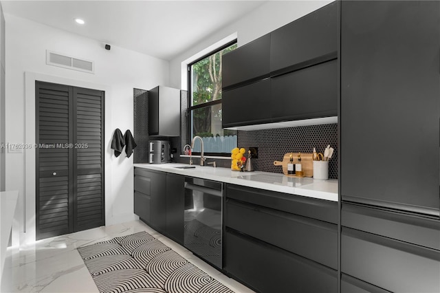 kitchen featuring visible vents, backsplash, black dishwasher, marble finish floor, and a sink