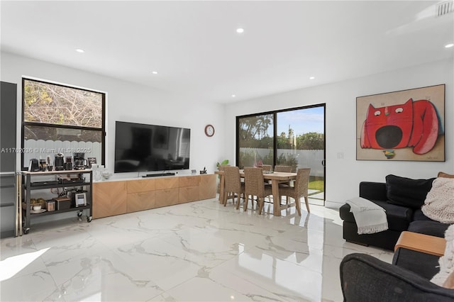 living area with recessed lighting, visible vents, and marble finish floor