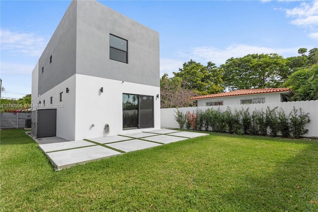 back of property with a yard, a patio, a fenced backyard, and stucco siding