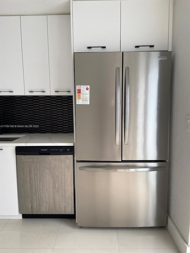 kitchen with a sink, stainless steel appliances, light countertops, white cabinets, and modern cabinets