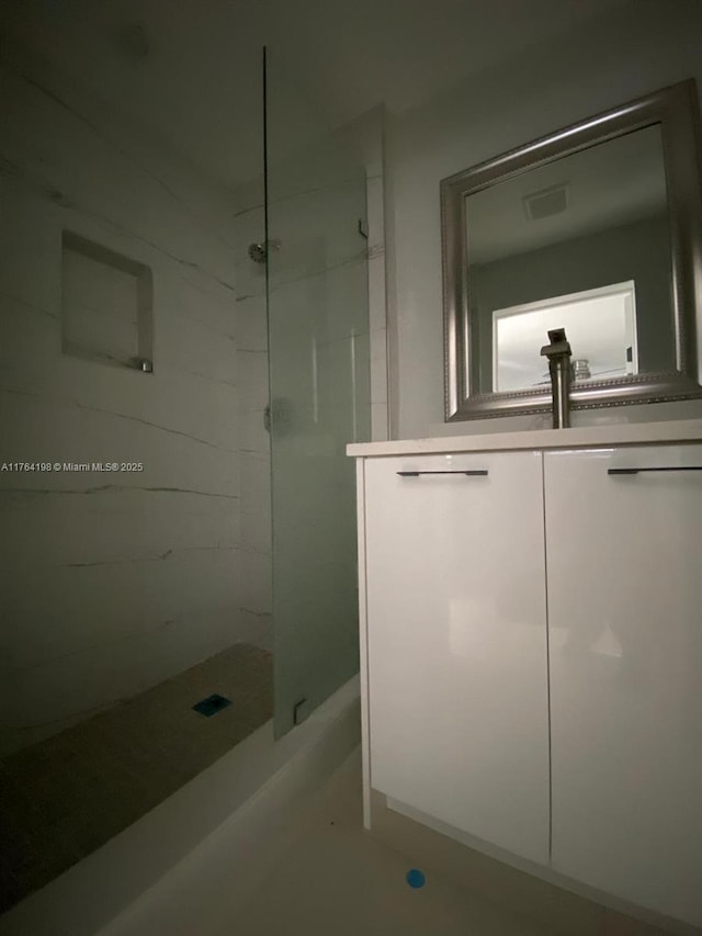 full bath featuring vanity, visible vents, and a stall shower