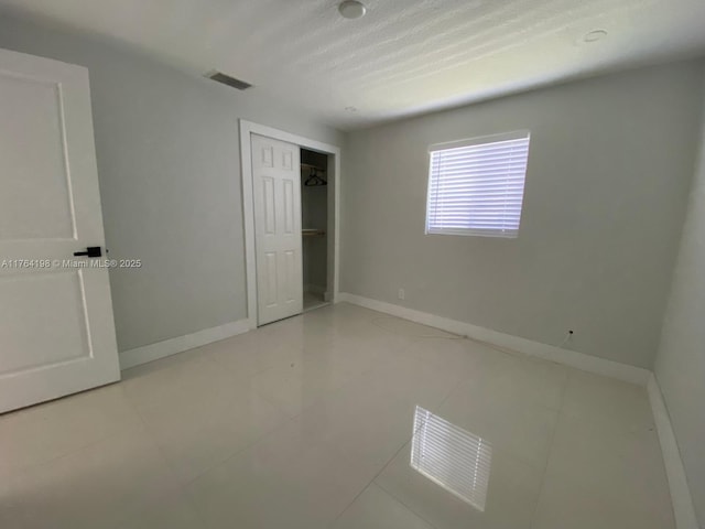 unfurnished bedroom featuring a closet, visible vents, and baseboards