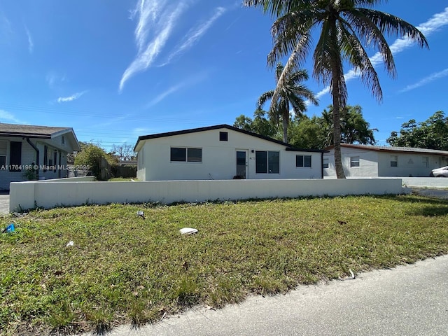 manufactured / mobile home featuring a front lawn and fence