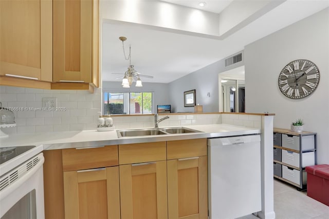 kitchen featuring white appliances, visible vents, a sink, light countertops, and tasteful backsplash