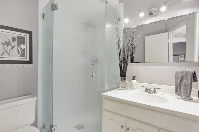 full bath with vanity, toilet, and a stall shower