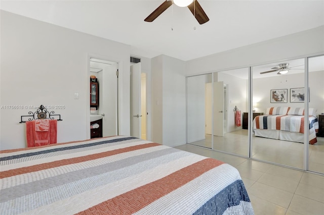 bedroom with light tile patterned floors, visible vents, ceiling fan, and a closet