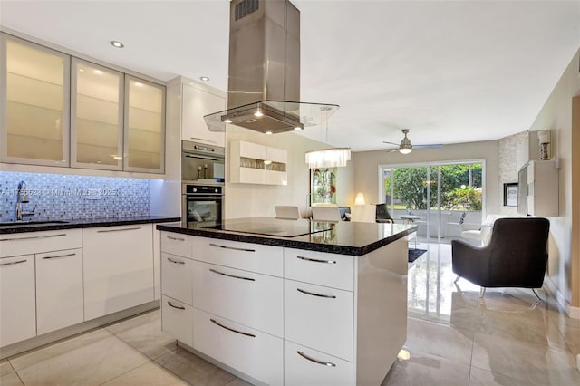 kitchen featuring ceiling fan, island exhaust hood, modern cabinets, black electric cooktop, and a sink