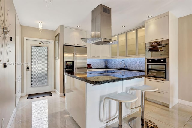 kitchen with tasteful backsplash, appliances with stainless steel finishes, island exhaust hood, a kitchen breakfast bar, and modern cabinets