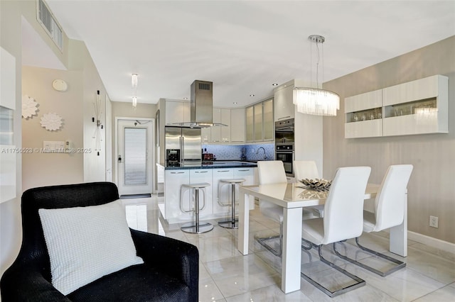 kitchen with visible vents, a breakfast bar, a kitchen island, range hood, and high quality fridge