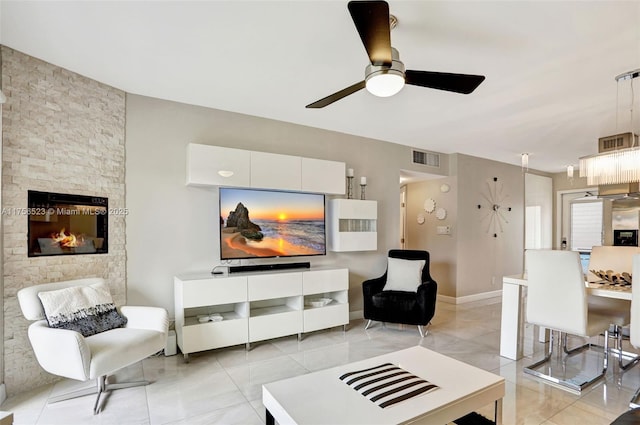 living area featuring visible vents, baseboards, and a ceiling fan