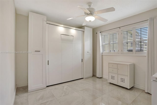 unfurnished bedroom with baseboards, a closet, and ceiling fan