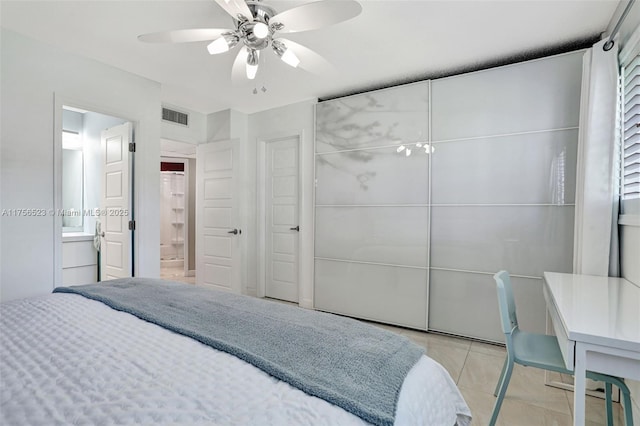 bedroom featuring visible vents, ensuite bathroom, a closet, light tile patterned floors, and ceiling fan