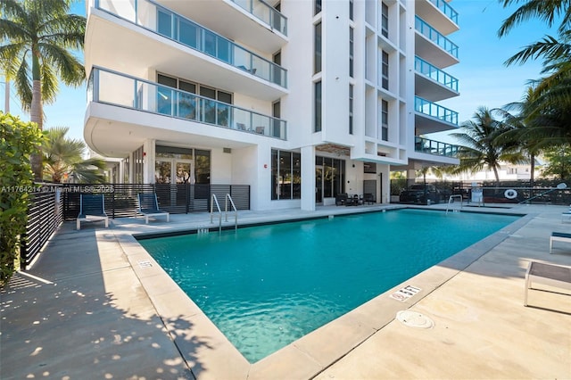 pool with a patio and fence