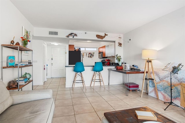 living area with light tile patterned floors and visible vents