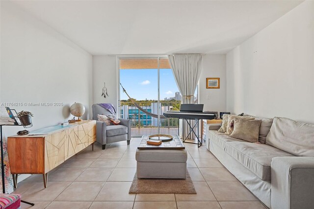 living room with a wall of windows and light tile patterned floors