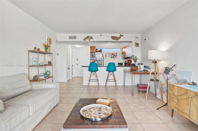 living area with light tile patterned floors and visible vents