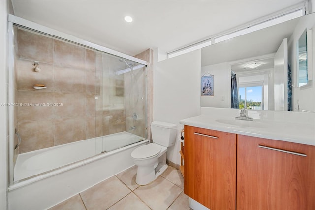 bathroom featuring bath / shower combo with glass door, toilet, vanity, and tile patterned flooring