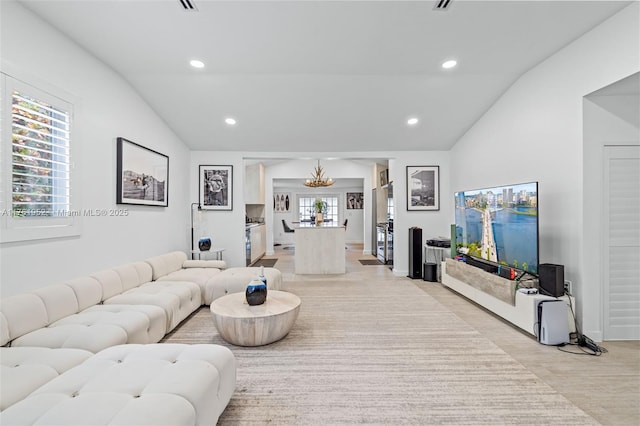 living room with vaulted ceiling, recessed lighting, and an inviting chandelier