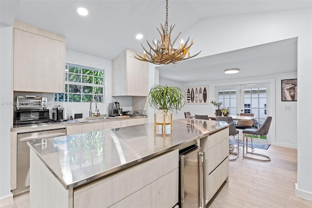kitchen with modern cabinets, wine cooler, stainless steel countertops, an inviting chandelier, and stainless steel dishwasher