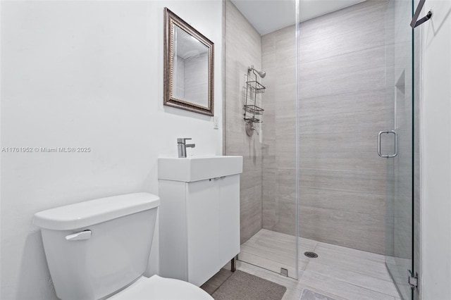 full bath with toilet, vanity, and a stall shower