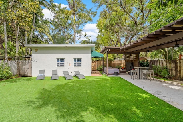 back of house with a fenced backyard, a patio, stucco siding, and a lawn