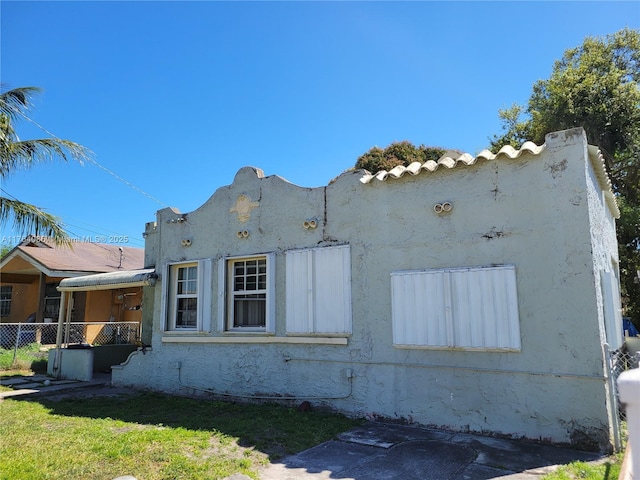 view of property exterior featuring stucco siding and fence