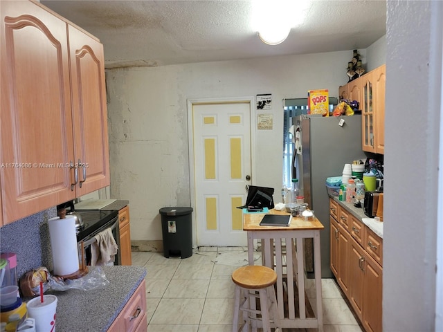 kitchen featuring light tile patterned floors, stainless steel range with electric stovetop, a textured ceiling, and glass insert cabinets