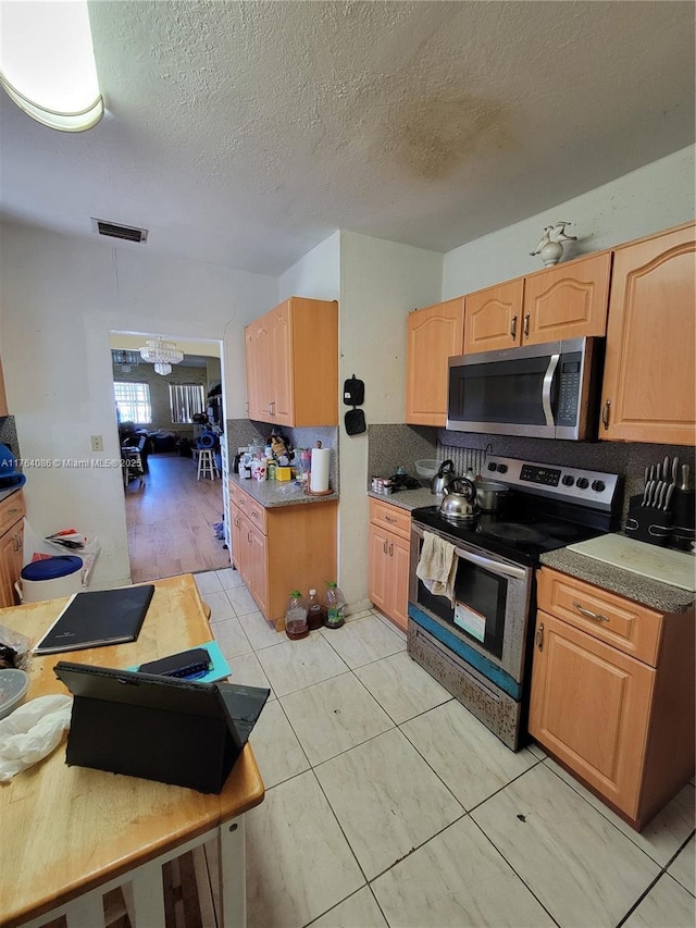 kitchen featuring visible vents, a notable chandelier, light brown cabinets, tasteful backsplash, and stainless steel appliances