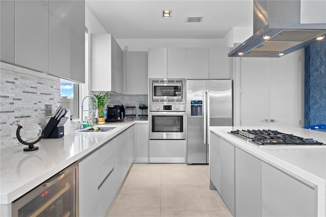 kitchen with visible vents, modern cabinets, beverage cooler, range hood, and built in appliances