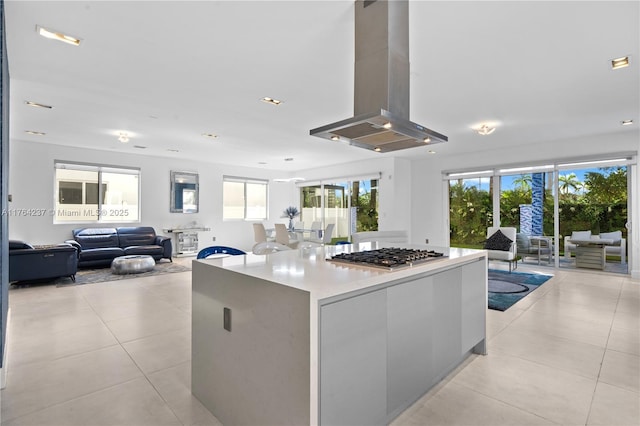 kitchen with a kitchen island, island range hood, open floor plan, stainless steel gas stovetop, and modern cabinets