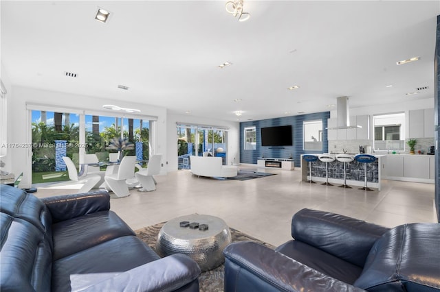 living area featuring light tile patterned floors, recessed lighting, and visible vents