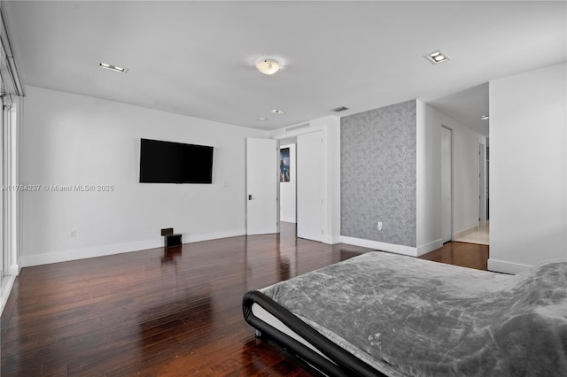 bedroom with visible vents, baseboards, and wood finished floors