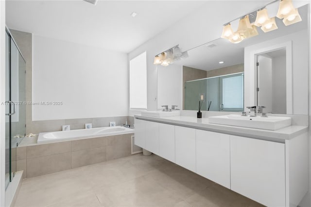 bathroom featuring double vanity, a notable chandelier, a stall shower, and a sink