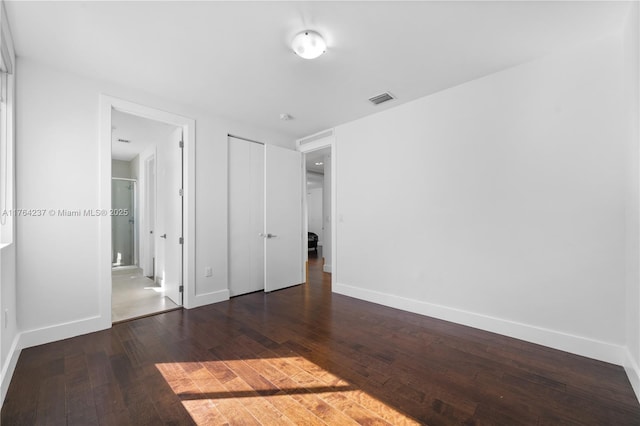 unfurnished bedroom with visible vents, baseboards, and hardwood / wood-style floors