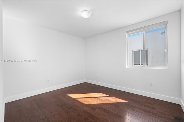 unfurnished room featuring wood finished floors and baseboards