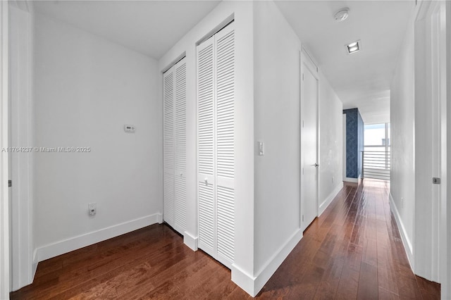 hallway with baseboards and dark wood finished floors