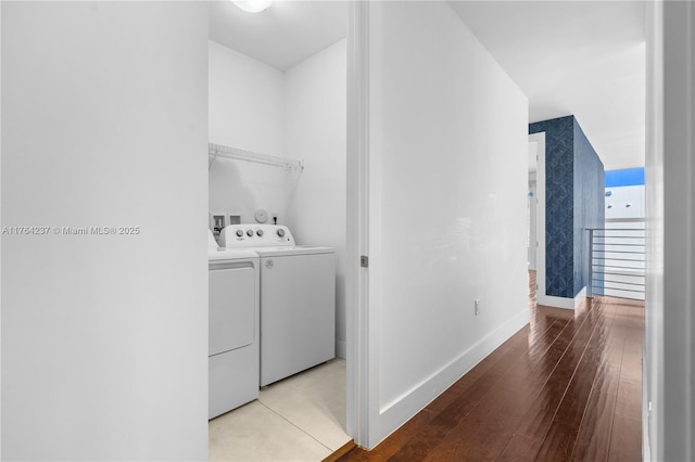 laundry room featuring laundry area, light wood-style floors, baseboards, and washing machine and clothes dryer