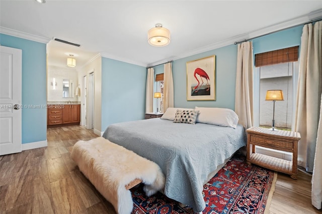 bedroom featuring visible vents, light wood-style flooring, baseboards, and ornamental molding